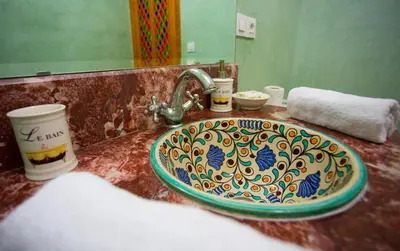 a bathroom sink with a colorful plate on it at Riad Vega in Fès