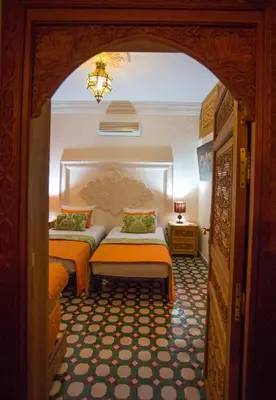two beds in a room with an archway at Riad Vega in Fès