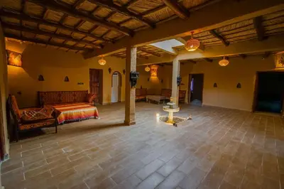 a large living room with a couch and a television at Riad Marhaba Merzane in Merzane
