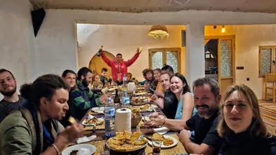 a group of people sitting at a table eating food at Riad Marhaba Merzane in Merzane