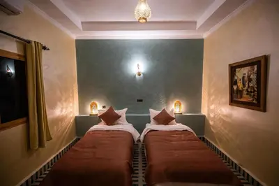 a room with two beds in a room with at Riad Les jardins de Merzouga in Merzouga