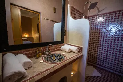 a bathroom with a sink and a mirror at Riad Les jardins de Merzouga in Merzouga