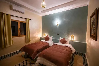 a bedroom with two beds in a room at Riad Les jardins de Merzouga in Merzouga
