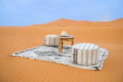 a table and two barrels in the desert at Riad Kasbah Aiour in Merzouga