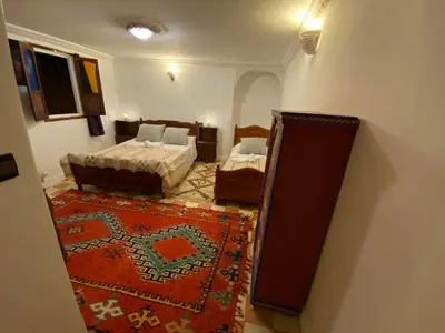 a view of a bedroom with two beds and a rug at Dar benelmahi in Fès
