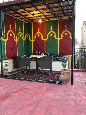 a patio with two chairs and a table and a colorful wall at Dar benelmahi in Fès