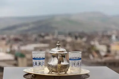a tea pot and two cups on a tray at Dar benelmahi in Fès