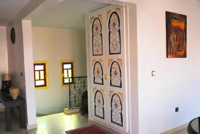 a hallway with a door with stained glass at Appartement Anatim in Ouarzazate