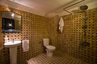 a bathroom with a sink and a toilet and a mirror at Dar El Mathaf FES in Fès