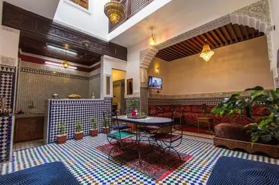 a lobby with a table and chairs and a couch at Dar El Mathaf FES in Fès