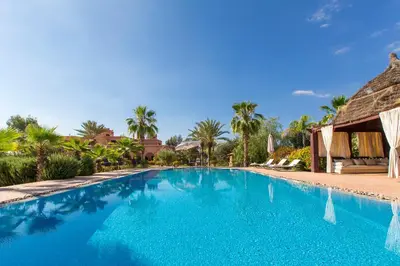 a swimming pool at a resort with palm trees at Ksar Salha in Marrakech