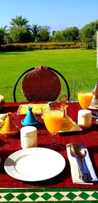 a table with a plate and glasses of orange juice at Ksar Salha in Marrakech