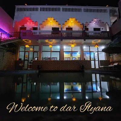 a house with a swimming pool at night at Dar Ilyana in Tamezmoute