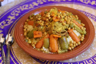 a plate of food with carrots and vegetables on a table at Dar Ilyana in Tamezmoute