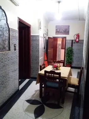 a dining room with a wooden table and chairs at La Perle in Meknès