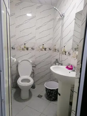 a white bathroom with a toilet and a sink at La Perle in Meknès