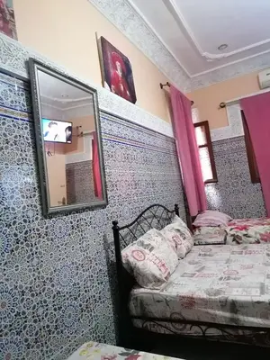 a bedroom with a bed and a mirror at La Perle in Meknès