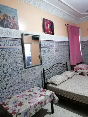 a bedroom with a mirror and two beds in it at La Perle in Meknès