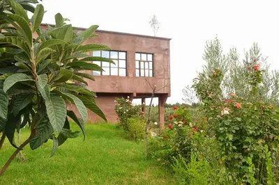 a house in the middle of a yard with plants at Villa Paradise in Aghmat