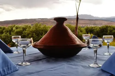 a table with wine glasses and a bell on it at Villa Paradise in Aghmat