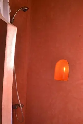 a shower with an orange light on a wall at Villa Paradise in Aghmat