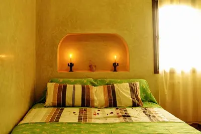 a bedroom with a bed with two candles on the wall at Villa Paradise in Aghmat