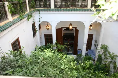 an entry to a white house with plants at Riad Lune et Soleil in Fès