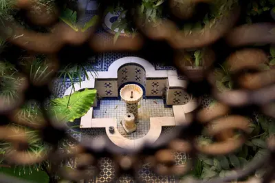 a view of a clock through a chain link fence at Riad Lune et Soleil in Fès