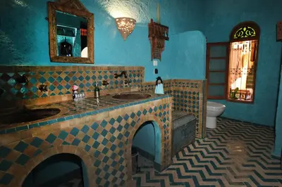 a blue bathroom with a sink and a toilet at Riad Lune et Soleil in Fès