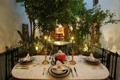 a table with plates and utensils on top at Riad Lune et Soleil in Fès