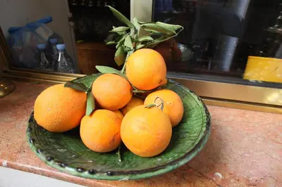 a green bowl filled with oranges on a counter at Riad Lune et Soleil in Fès