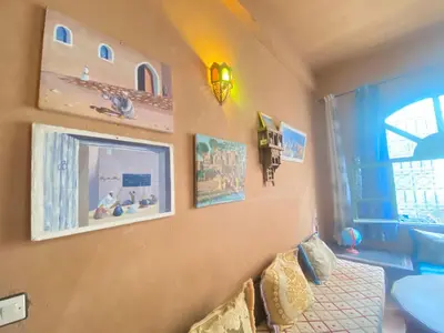 a bedroom with a bed and pictures on the wall at Riad Dar Barbara in Ouarzazate
