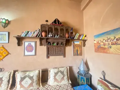 a living room with a couch and shelves on the wall at Riad Dar Barbara in Ouarzazate