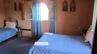 a bedroom with two beds and a window at Riad Dar Barbara in Ouarzazate