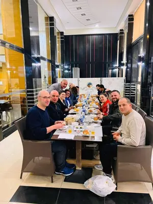 a group of people sitting around a long table at Hotel La Luna in Beni Mellal
