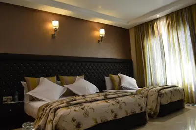 a hotel room with two beds with white pillows at Hotel La Luna in Beni Mellal