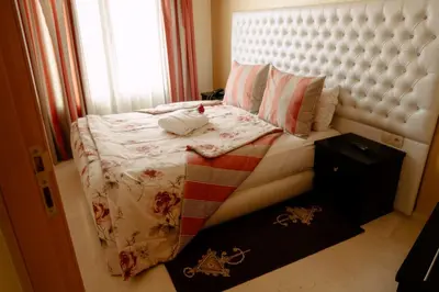 a small bedroom with a bed with a white headboard at Hotel La Luna in Beni Mellal