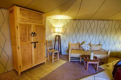 a room with a couch and a table in a tent at Madu Luxury Desert Camp in Merzouga