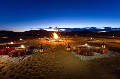 a lit up tent in the desert at night at Madu Luxury Desert Camp in Merzouga