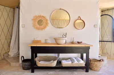 a bathroom with a sink and mirrors on the wall at Madu Luxury Desert Camp in Merzouga