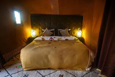 a bedroom with a large bed with flowers on it at Madu Luxury Desert Camp in Merzouga