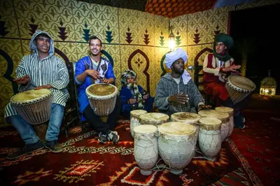 a group of people sitting around drums in a room at Madu Luxury Desert Camp in Merzouga