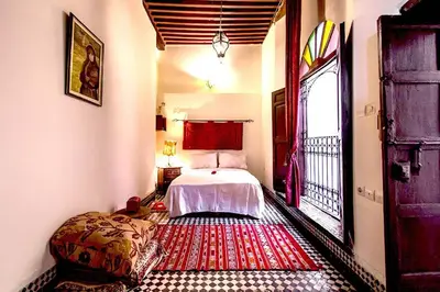 a bedroom with a bed and a large window at Dar Nineta in Fès