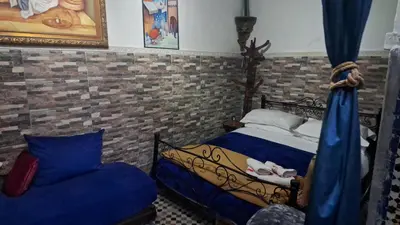 a bedroom with a bed and a couch and a bedskirtspectspectspectspects at Dar Nineta in Fès