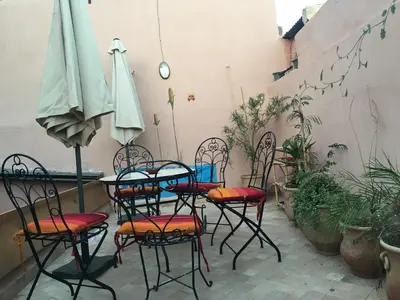 a patio with a table and chairs and an umbrella at Dar Nineta in Fès