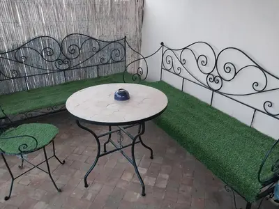 a table and two chairs sitting next to a bench at Dar Nineta in Fès