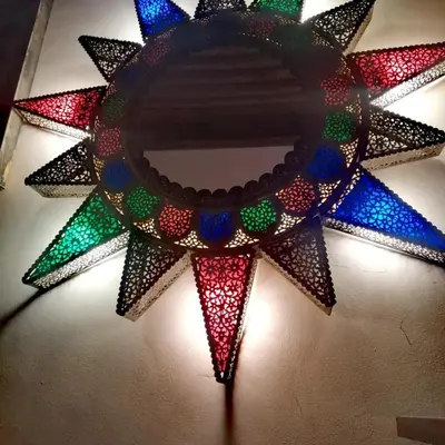 a lighted star with colorful lights on a wall at Les Bains de Fez Tara in Fès