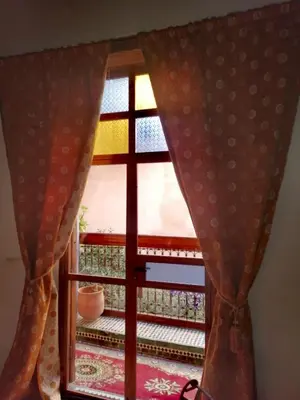 a window in a room with curtains and a table at Les Bains de Fez Tara in Fès