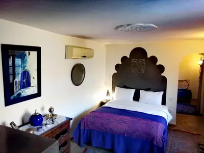 a bedroom with a large bed with a purple bedspread at Les Bains de Fez Tara in Fès