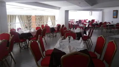 a dining room with tables and red chairs at Hotel Arena Fes in Fès